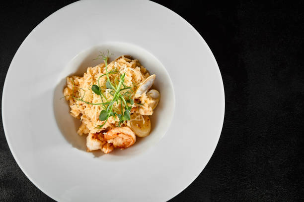 istock Delicious Seafood Risotto with Scallops and Shrimp on Elegant White Plate 2159119087
