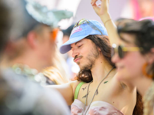 Vienna, Austria - June 08, 2024: People at Vienna Pride in summer on Wiener Ringstrasse, portrait of a man with a blue cap dancing