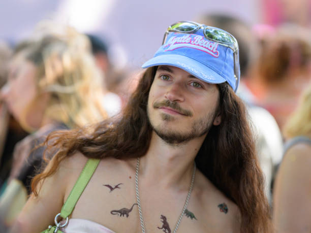 Vienna, Austria - June 08, 2024: People at Vienna Pride in summer on Wiener Ringstrasse, portrait of a man with a beard and a blue cap dancing