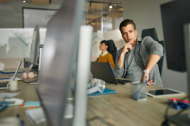 istock Pensive businessman working on laptop at corporate office. 2159122512