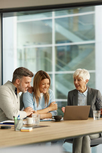 istock Happy couple using laptop with their financial advisor in the office. 2159122889