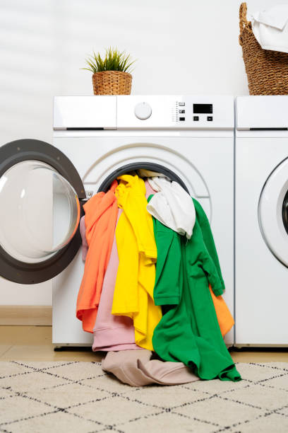 istock White Laundry Appliances With Colorful Clothes Overflowing From Washing Machine 2159123363