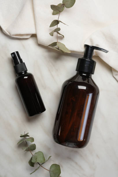 istock Brown glass bottles and eucalyptus leaves on white marble background. Flat lay, top view, copy space. Minimalist concept. 2159123768