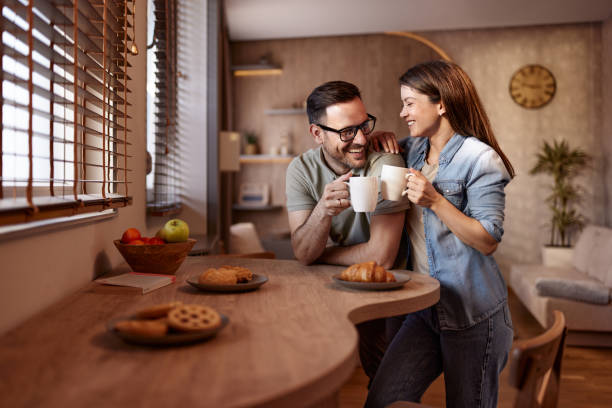 Happy couple toasting with coffee at home.