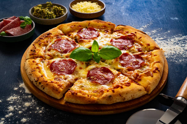 istock Circle pepperoni pizza with mozzarella cheese on black wooden table 2159124283