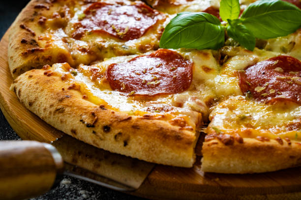 istock Circle pepperoni pizza with mozzarella cheese on black wooden table 2159124306