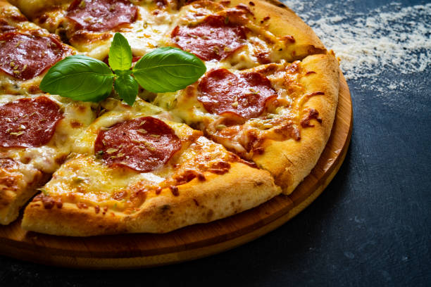 istock Circle pepperoni pizza with mozzarella cheese on black wooden table 2159124343