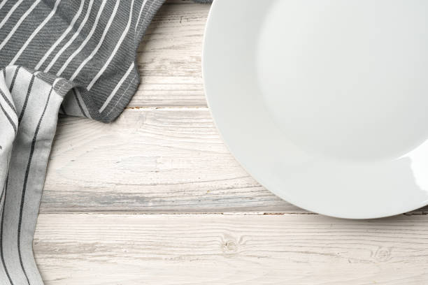 istock White ceramic plate on wooden background top view 2159124440