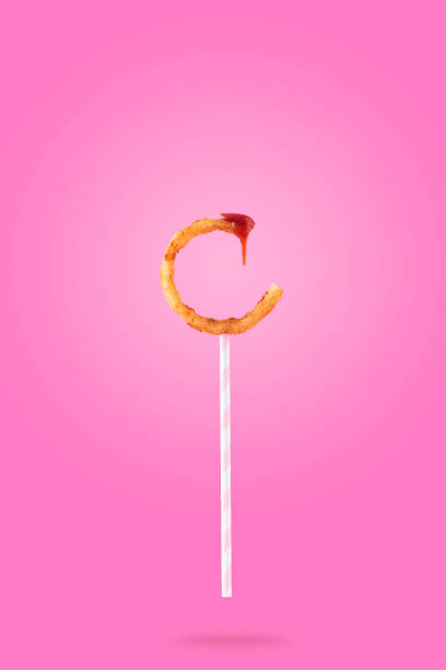 Fried onion rings on a pink background