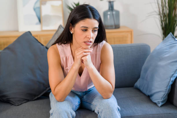 istock woman feeling sad and depressed while sitting on sofa at home 2159125588