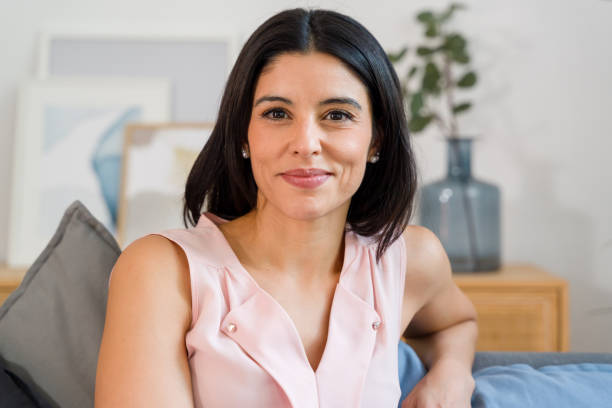 istock businesswoman smiling while sitting on sofa 2159126044