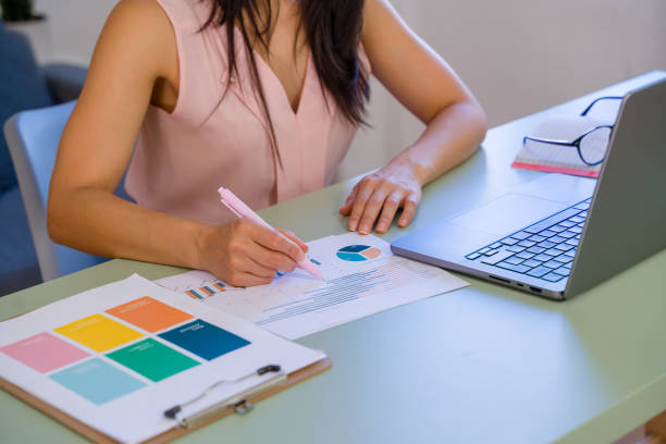 istock Businesswoman analyzing charts and graphs on desk with laptop 2159126207