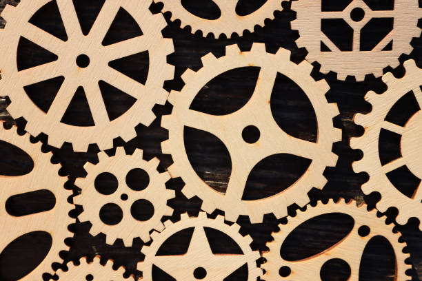 istock Set of spinning gears on wooden table 2159126630