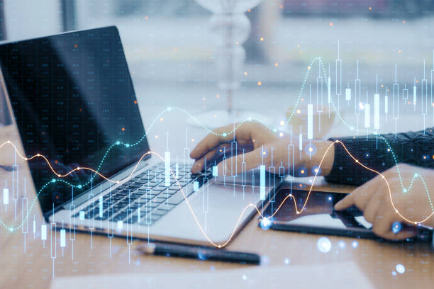 istock Hands typing on a laptop with financial graphs overlaying the image, set on a desk, concept of business analytics 2159126774