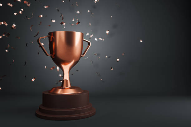 istock A bronze trophy cup with confetti on a dark background, symbolizing celebration of victory or success. 3D Rendering 2159126815