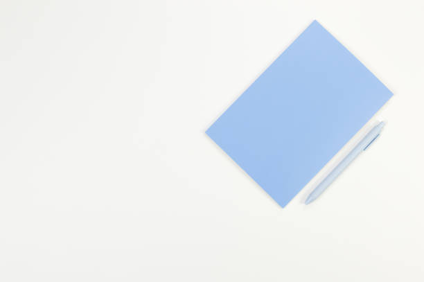 istock Top view of blue notebook, blue pen on white background. School, office wallpaper. 2159132595
