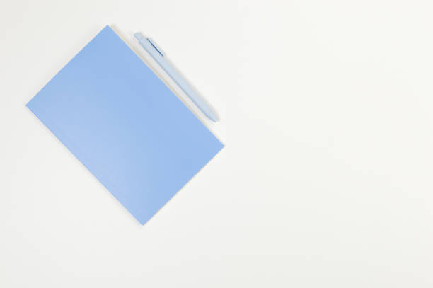 istock Top view of blue notebook, blue pen on white background. School, office wallpaper. 2159132600