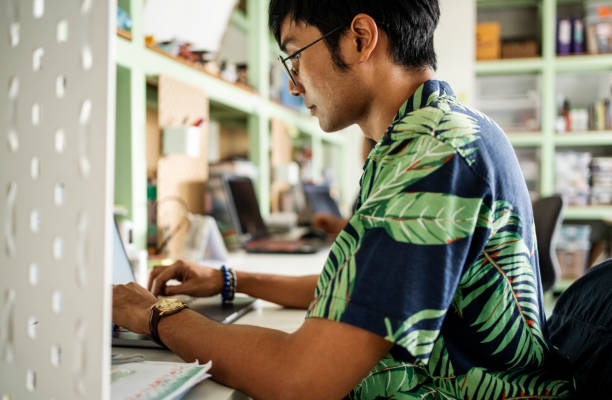istock Young asian man working online on a laptop at startup office 2159133003