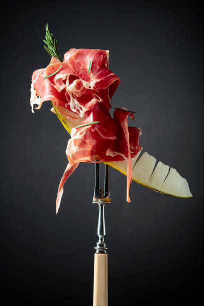 istock Melon with prosciutto and rosemary on a black background. 2159133177