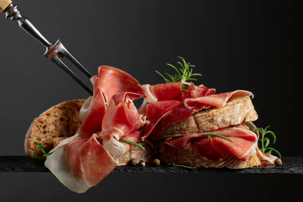 istock Ciabatta with prosciutto and rosemary on a black background. 2159133216