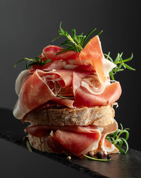 istock Ciabatta with prosciutto and rosemary on a black background. 2159133237