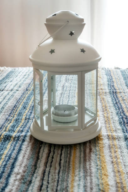 Christmas or winter home concept with white lantern with candle close-up on the table