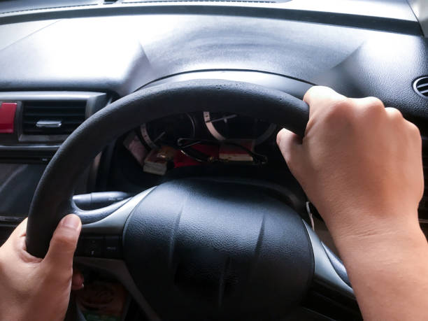 istock Hand holding the steering wheel of a car 2159134971