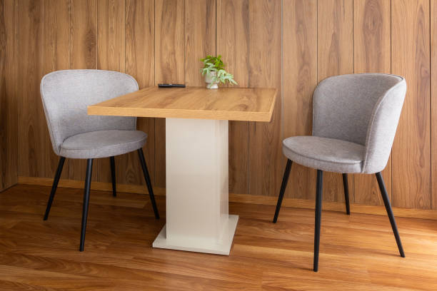 istock Modern chairs at dining table, wooden wall 2159135179