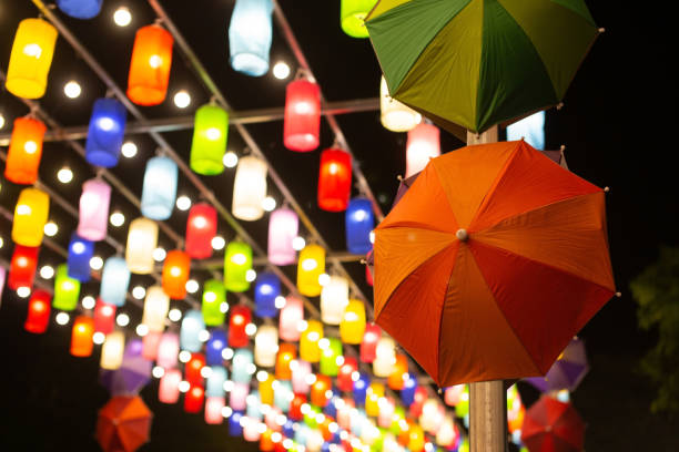 Colorful umbrellas with decorative lights on a black background.