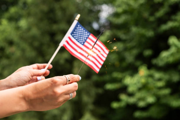 Woman holding small American flag. USA Memorial or Independence day concept.
