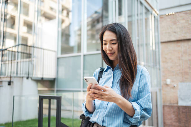 istock Asian woman using smartphone while commuting in urban environment. 2159141453
