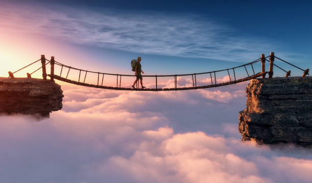 Man walking on a rope suspension bridge.
