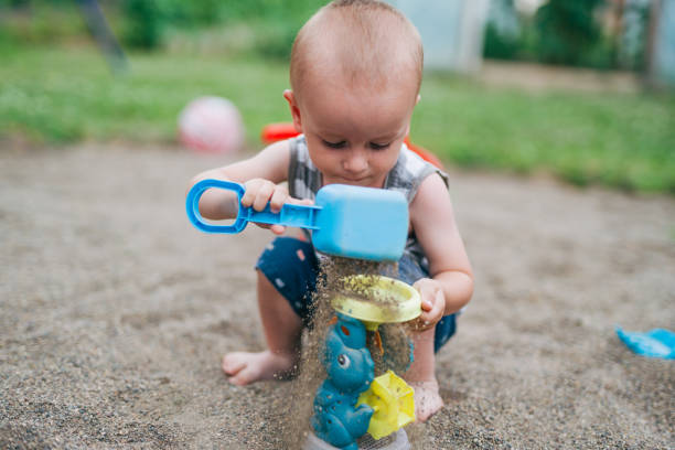 boy is playing in the sand in the backyard