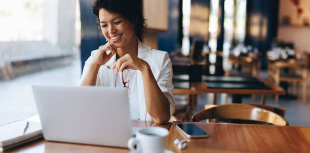 istock Businesswoman working in a cafe using laptop, freelancer with glasses 2159144905