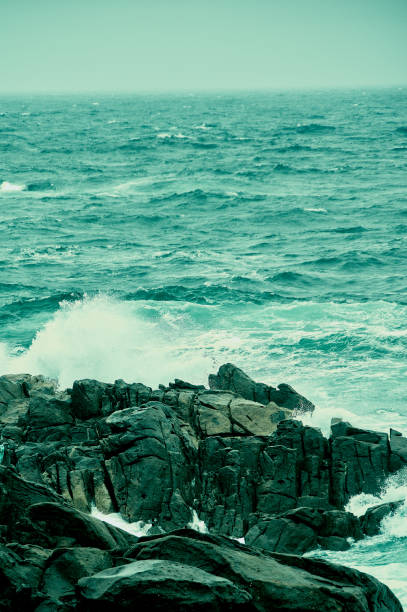 istock Emerald sea breaking on the rocks of a cliff 2159145404