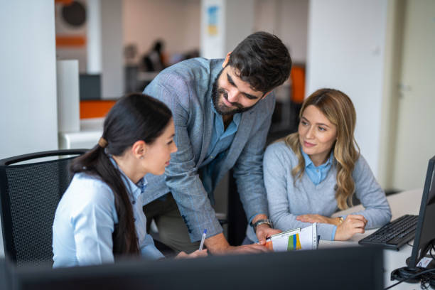 istock Busy marketing team analyzing work results together, discussing paper sales reports, bending over meeting table, pointing at documents, brainstorming on creative strategy. 2159147925