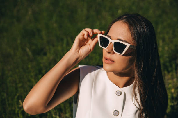 istock a young woman in sunglasses with a white frame on a summer green background 2159149531