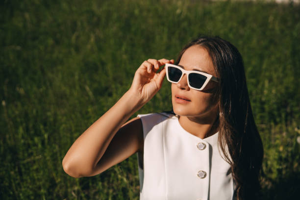 istock a young woman in sunglasses with a white frame on a summer green background 2159149532