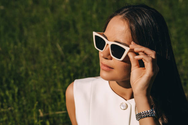 istock a young woman in sunglasses with a white frame on a summer green background 2159149538