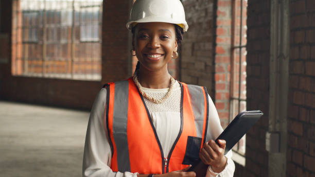 istock Confident Female Engineer on Construction Site Holding Tablet and Wearing Safety Gear 2159149954
