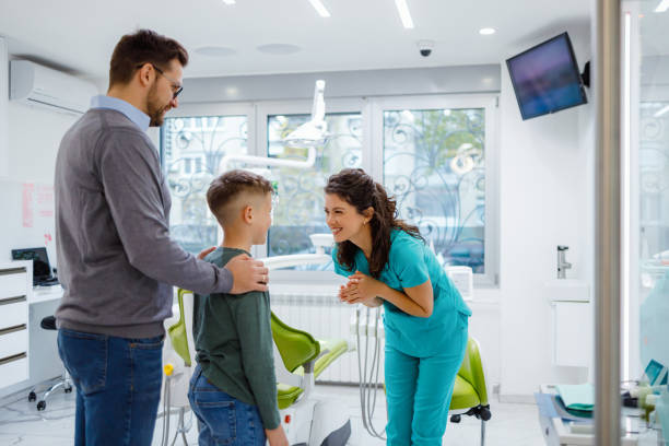 istock Supportive father and dentist talks with little boy 2159150090