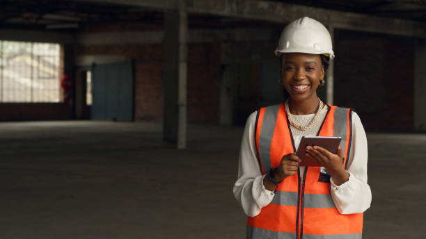 istock Confident Woman Engineer Wearing Safety Gear Using Tablet in Construction Site 2159150313