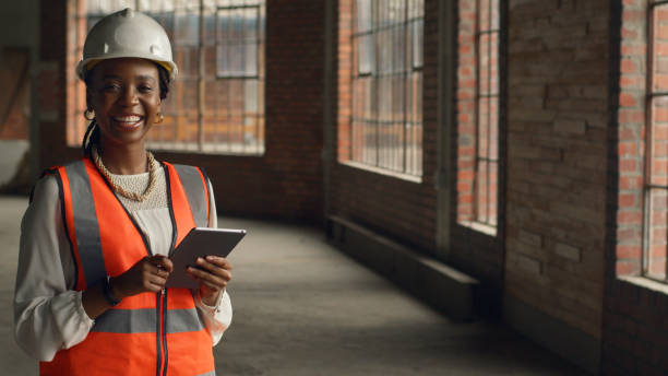istock Confident Female Engineer in Safety Gear Holding Tablet in a Construction Site 2159150318