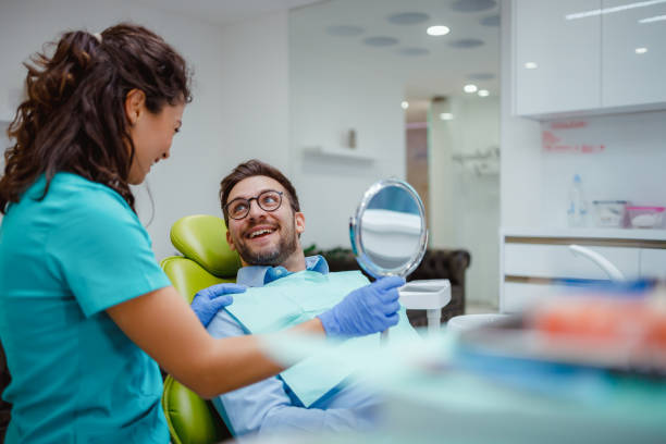 istock Happy patient holding mirror in modern dental office. 2159150542
