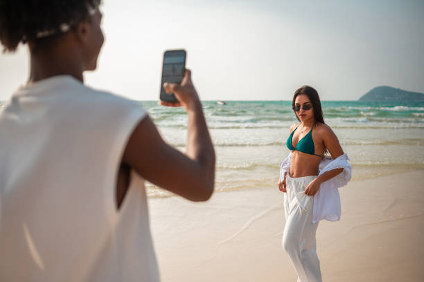istock Man Captures Girlfriend's Beach Moments with Smartphone 2159151488
