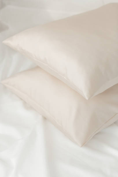 istock Beige satin (lyocell, silk, polyester) pillowcases on the bed. Home textile. 2159153998