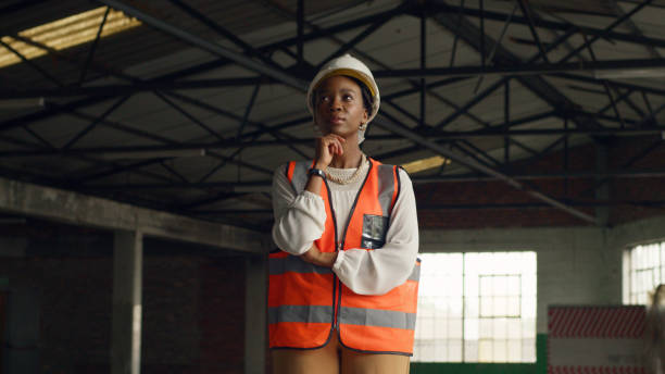 istock Female Architect in a Construction Site Wearing Safety Gear and Reflecting on Future Projects 2159154249