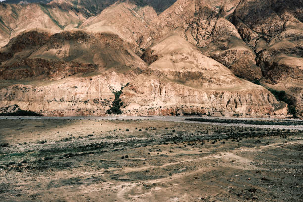 istock Aerial perspective capturing a expansive river carving its way through a desert-like valley cradled by imposing peaks 2159155008