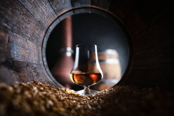 ein glas bourbon whiskey im eichenfass - holzfass stock-fotos und bilder