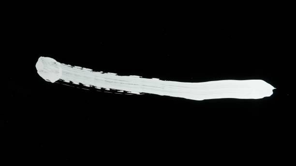 istock White paint streak drawn on glass surface. Drawing with white acrylic paint on black isolated background. Monochrome art painting, minimalism 2159159255